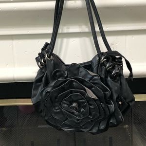 A black purse with a rose design